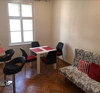 Jídelní kout ve 2-pokojovém bytě s podlahou s dřevěným dekorem a stylovým sezením.