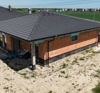 Rodinný dům v Bernolákově s cihlovou fasádou a tmavou střechou.