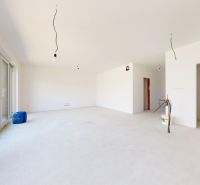 Rozestavěný interiér rodinného domu s velkými okny a prostornou místností.
