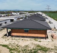 Staveniště rodinných domů v Bernolákově se současnými střechami a přilehlou cestou.