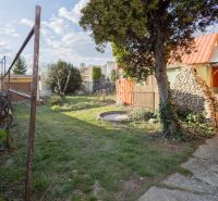 Zahrada rodinného domu na Mlynské ulici v Piešťanech s trávníkem a stromy.