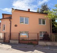 Rodinný dům na Mlynské ulici v Piešťanech s bílými okny, oranžovou fasádou a plotem.