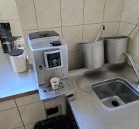 Kuchyňský kout s kávovarem, nerezovým dřezem a potřebami v gastro prostorech.