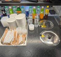 Interiér gastro prostorů s nápoji, sklenicemi, miskami a příbory připravenými k servírování.