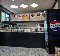 Gastro prostory s nabídkou nápojů, ledničkou Pepsi a dlažbou s ornamenty.