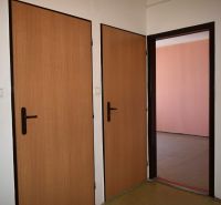 Interiér 3-pokojového bytu s dveřmi s dřevěným dekorem a telefonem na stěně.