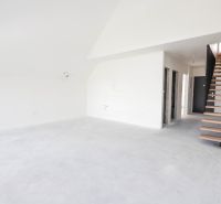 Interiér 4-pokojového bytu s betonovou podlahou a dřevěným schodištěm.