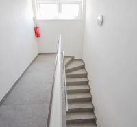 Schodiště s jednoduchým zábradlím a okny ve 4pokojovém bytě.