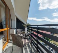 Balkon s ratanovým posezením a květinovou výzdobou ve 4-pokojovém bytě ve Vyšných Hágoch.