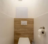Minimalistická toaleta se závěsným WC a podlahou s dřevěným dekorem ve 4-pokojovém bytě.