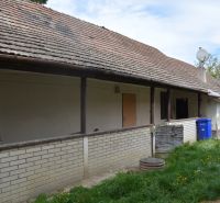 Exteriér rodinného domu v Horních Salibách se sedlovou střechou a cihlovým obkladem.