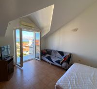 Pokoj v rekreačním apartmánu s balkónem a výhledem na moře, televizí a pohovkou.