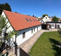 Rodinný dům ve městě Berg s červenou střechou a zeleným trávníkem.
