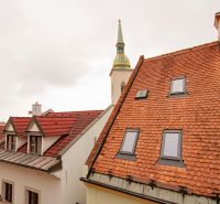 Kostelní věž vyčnívající nad střechami v Bratislavě na Beblavého ulici.