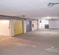 Parkovací garáže v Bratislavě na Majerníkově ulici s osvětlením a barevnými dveřmi.
