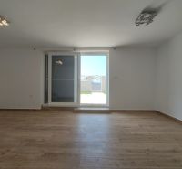 Pokoj s podlahou s dřevěným dekorem a balkónovými dveřmi v rodinném domě.
