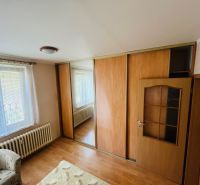 Bílá stěna, skříň s posuvnými dveřmi, podlaha s dřevěným dekorem, 3-pokojový byt.