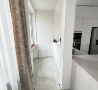 Kuchyně v 3-pokojovém bytě s bílými skříňkami a mramorovou podlahou.