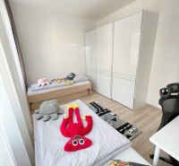 Dětský pokoj ve 3-pokojovém bytě s hračkami a podlahou s dřevěným dekorem.
