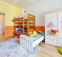 Dětský pokoj v rodinném domě s patrovou postelí a dekorovanou skříní, podlaha s dřevěným dekorem.