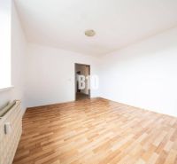 Světlá místnost se stěnami ve 4-pokojovém bytě a podlahou s dřevěným dekorem.