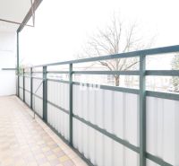 Balkon 3pokojového bytu s výhledem na stromy a dlažbou.