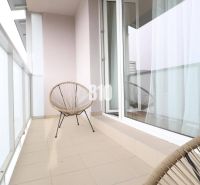 Balkon 1-pokojového bytu se dvěma židlemi a posuvnými dveřmi.