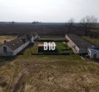 Výrobní prostory v Turecku se staršími budovami, uprostřed zemědělské krajiny.