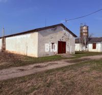 Výrobní prostory v Turej s zemědělskou architekturou a silem na pozadí.