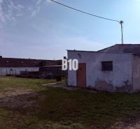 Výrobní prostory v exteriéru ve městě Turá s jednoduchými stavbami a travnatou plochou.