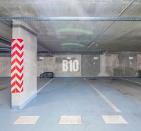 Podzemní parkoviště v Nitře s označeným parkovacím místem a betonovými sloupy.
