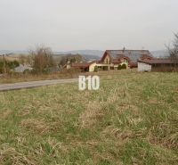 Pozemky - bydlení v obci Rosina, travnatý pozemek s okolím venkovských domů.