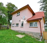 Rodinný dům v Makově s růžovou fasádou, zahrada a satelitní anténa na stěně.