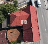 Střecha budovy v Belej a cesta s auty z ptačí perspektivy.