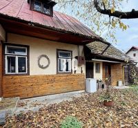 Rodinný dům v Kotešové se starým dřevěným opláštěním a padajícím listím na zahradě.