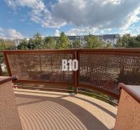 Výhled z balkonu v Rekreačním apartmánu na Halalovce v Trenčíně, obklopený stromy.