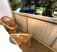 Balkon 1-pokojového bytu na Malé okružní v Partizánském s ratanovým posezením.