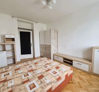 Ložnice s postelí, úložným nábytkem a podlahou s dřevěným dekorem ve 3-pokojovém bytě.