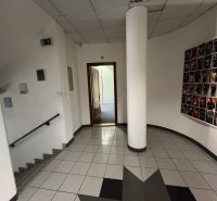 Chodba v kancelářích se schody a dekorací na stěně.