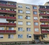 Bytový dům na ulici Nábrežná v Nových Zámcích s červenými balkóny.