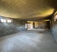 Interiér rozestavěné chaty s betonovými stěnami a podlahou.