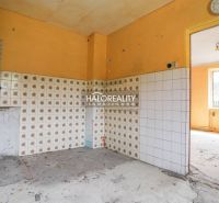 Kuchyně s oranžovými stěnami a vzorovanými obklady v rodinném domě.