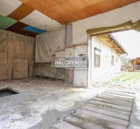Pohled na garáž v rodinném domě ve Stupném s provizorní dřevěnou podlahou.