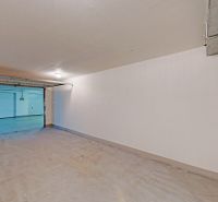 Garáže s otevřenými dveřmi, bílými stěnami a podlahou v Bratislavě - Petržalce.