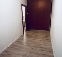 Chodba s vestavěnou skříní a podlahou s dřevěným dekorem ve 3-pokojovém bytě.