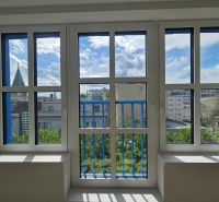 Pohled z 1-pokojového bytu na panoramu Bratislavy přes velká okna.