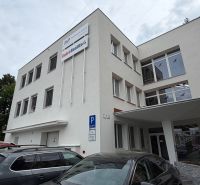 Budova kanceláří na Dlouhé ulici v Prievidzi se zaparkovanými auty.