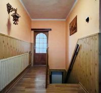 Chodba s dřevěným obkladem, podlahou s dřevěným dekorem a schodištěm v rodinném domě.