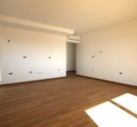 Světlá místnost s podlahou s dřevěným dekorem v rekreačním apartmánu.