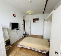Ložnice s matrací, televizorem a podlahou s dřevěným dekorem ve 3-pokojovém bytě.